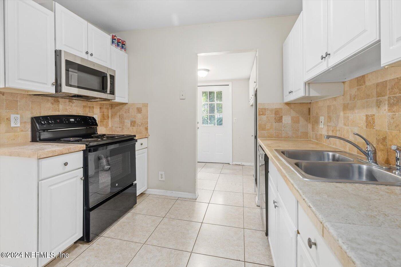 3724 South Lilly Road Jacksonville, FL 32207 - Photo 8 of 21 a kitchen with granite countertop a sink a stove and cabinets