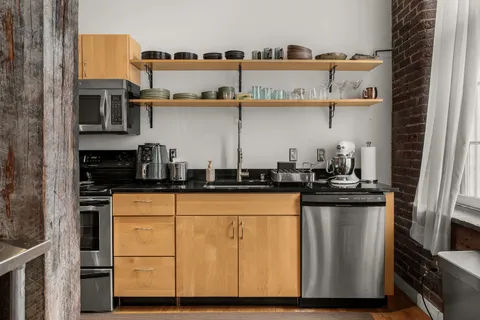 a kitchen with stainless steel appliances granite countertop a sink and cabinets
