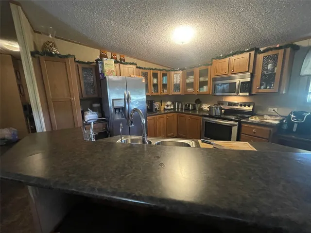 a view of a kitchen with stainless steel appliances a large counter top