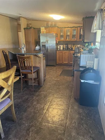 a dining room with a furniture and a kitchen view