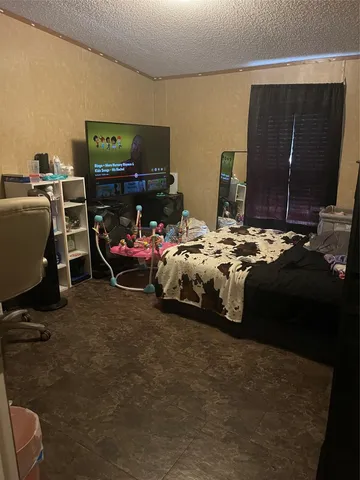 a bedroom with bed tv and a mirror