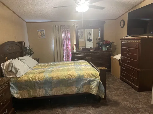 a bedroom with a bed and a flat tv screen on dresser