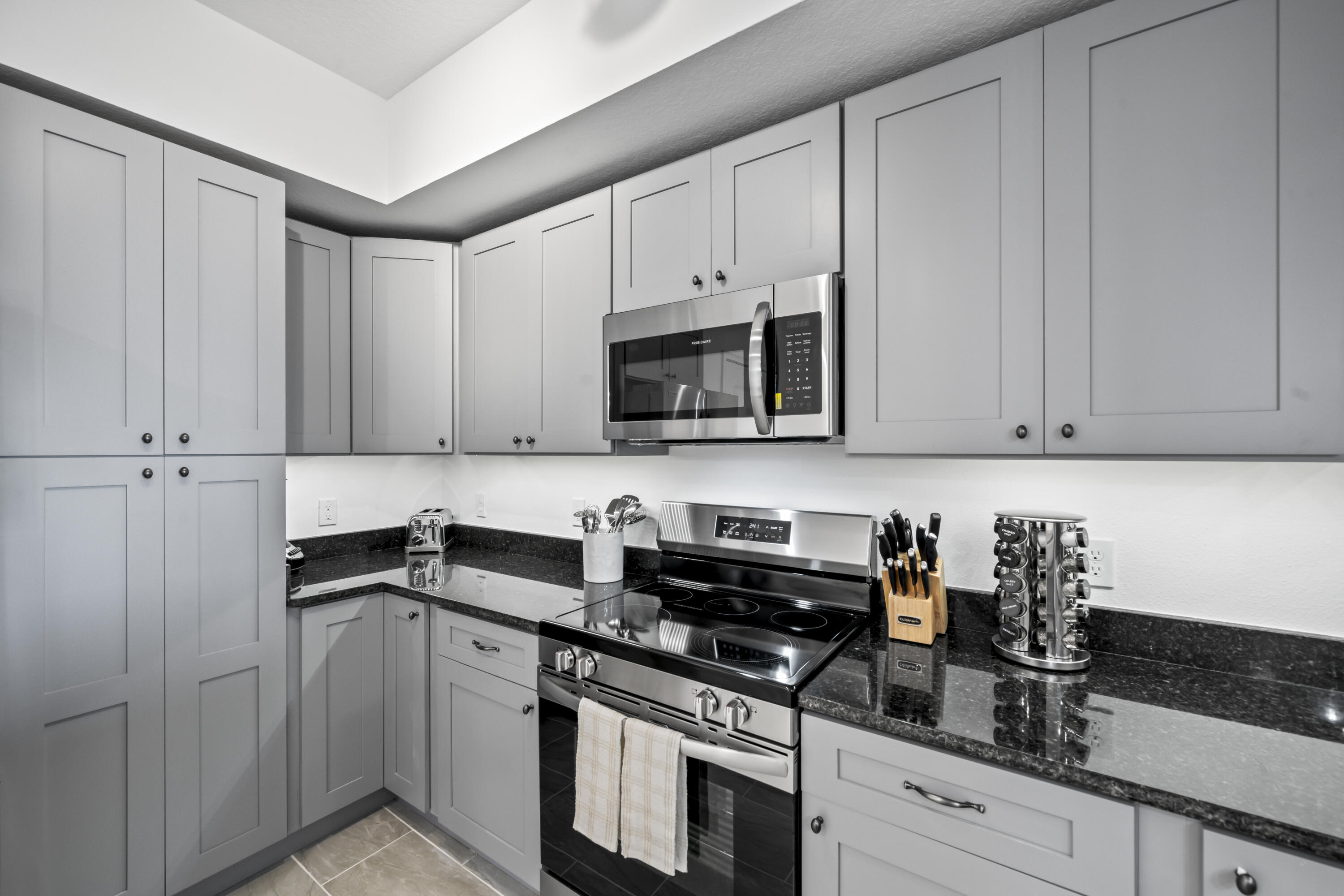 735 Pilot Lane, Unit 1004 Merritt Island, FL 32952 - Photo 10 of 46 a kitchen with stainless steel appliances granite countertop white cabinets and a stove