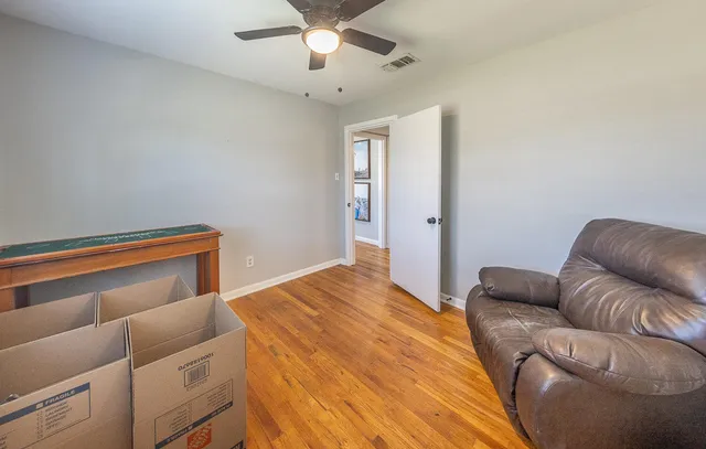 a bedroom with a bed couch and ceiling fan