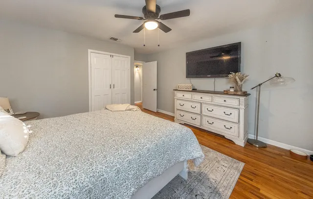 a spacious bedroom with a bed and flat screen tv
