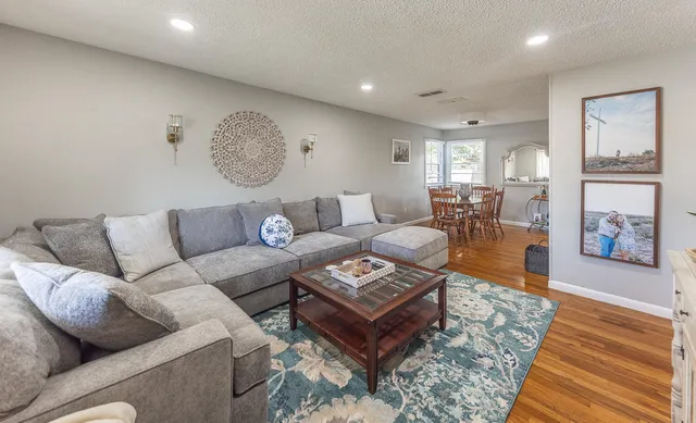 a living room with furniture and wooden floor