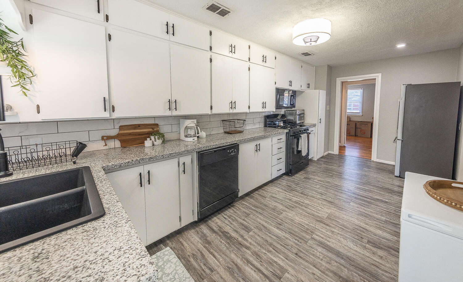 4206 42nd Street Lubbock, TX 79413 - Photo 8 of 25 a kitchen with stainless steel appliances granite countertop a sink stove and refrigerator
