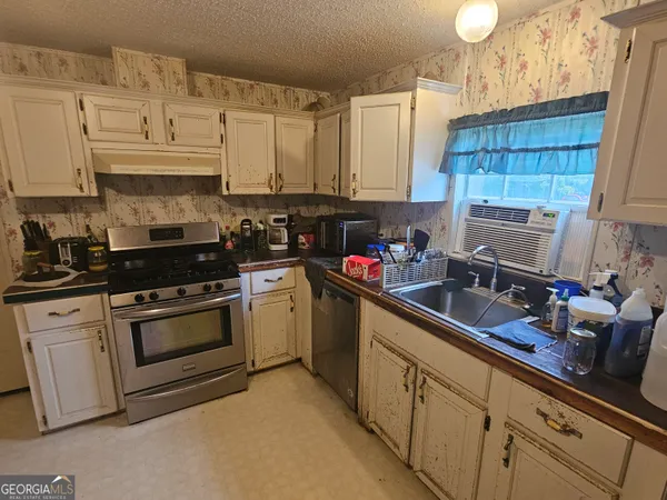 a kitchen with granite countertop a sink stainless steel appliances and cabinets