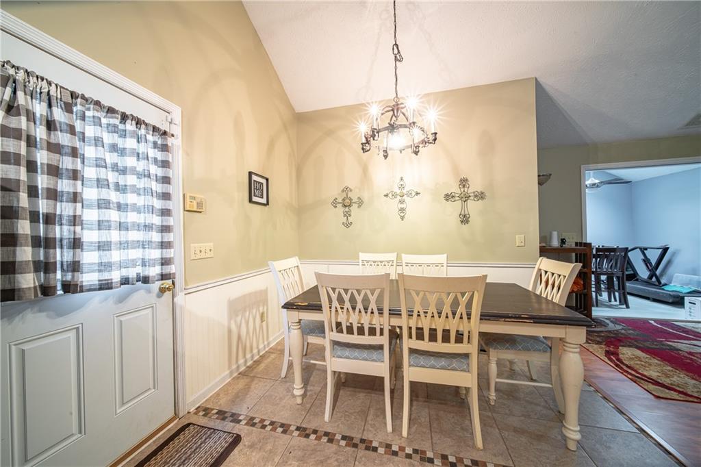 143 Lee Road 979 Phenix City, AL 36870 - Photo 19 of 37 Dining room with light tile patterned floors, a chandelier, and vaulted ceiling
