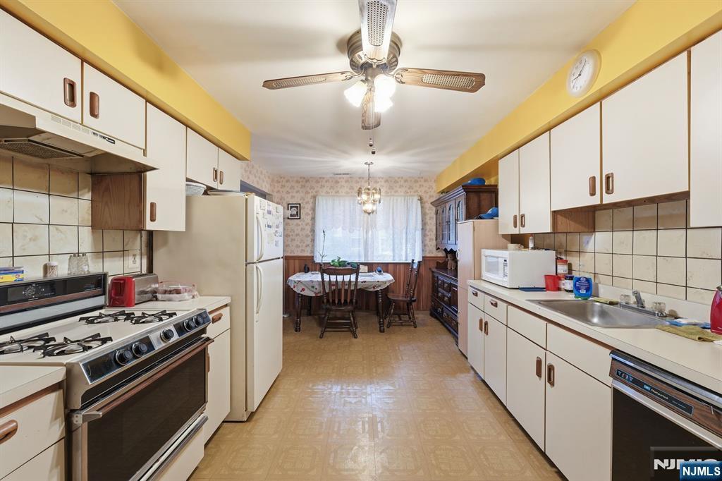 307 Edison Glen Terrace, Unit 307 Edison, NJ 08837 - Photo 4 of 10 a kitchen with a sink stainless steel appliances a window and a counter top space