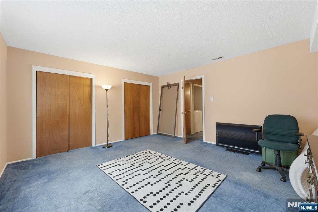 307 Edison Glen Terrace, Unit 307 Edison, NJ 08837 - Photo 7 of 10 a bedroom with a bed and a chair