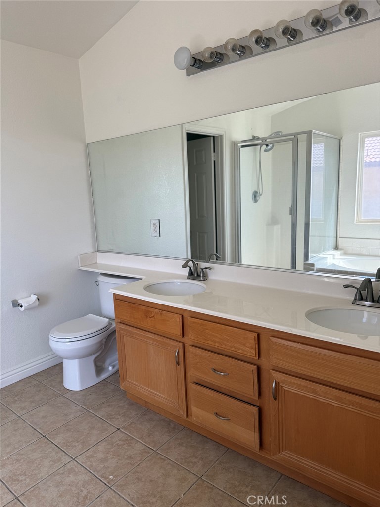1657 Stone Creek Road Beaumont, CA 92223 - Photo 17 of 32 a bathroom with a toilet sink and mirror