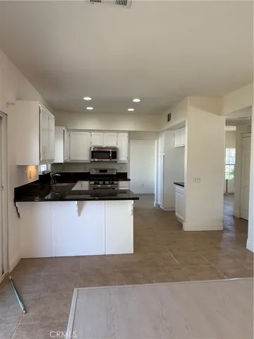 a view of kitchen with refrigerator stove and a sink