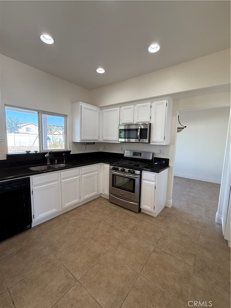 1657 Stone Creek Road Beaumont, CA 92223 - Photo 7 of 32 a large kitchen with cabinets a sink and white appliances