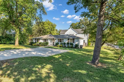 a front view of a house with yard and green space