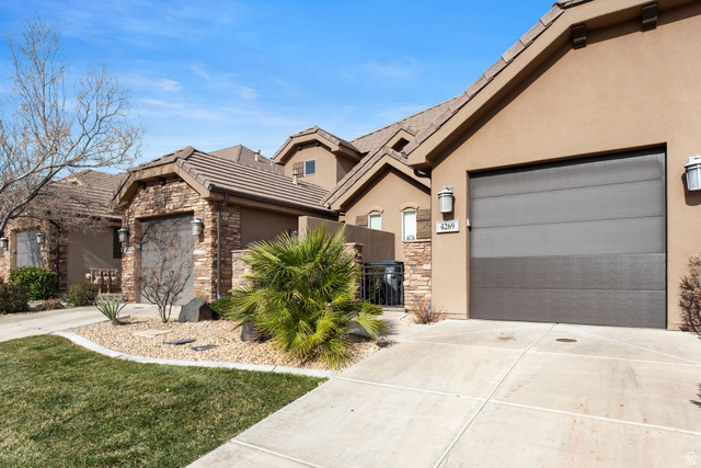 4269 Razor Drive Washington, UT 84780 - Photo 44 of 50 View of front of home featuring stone siding, stucco siding, concrete driveway, and an attached garage