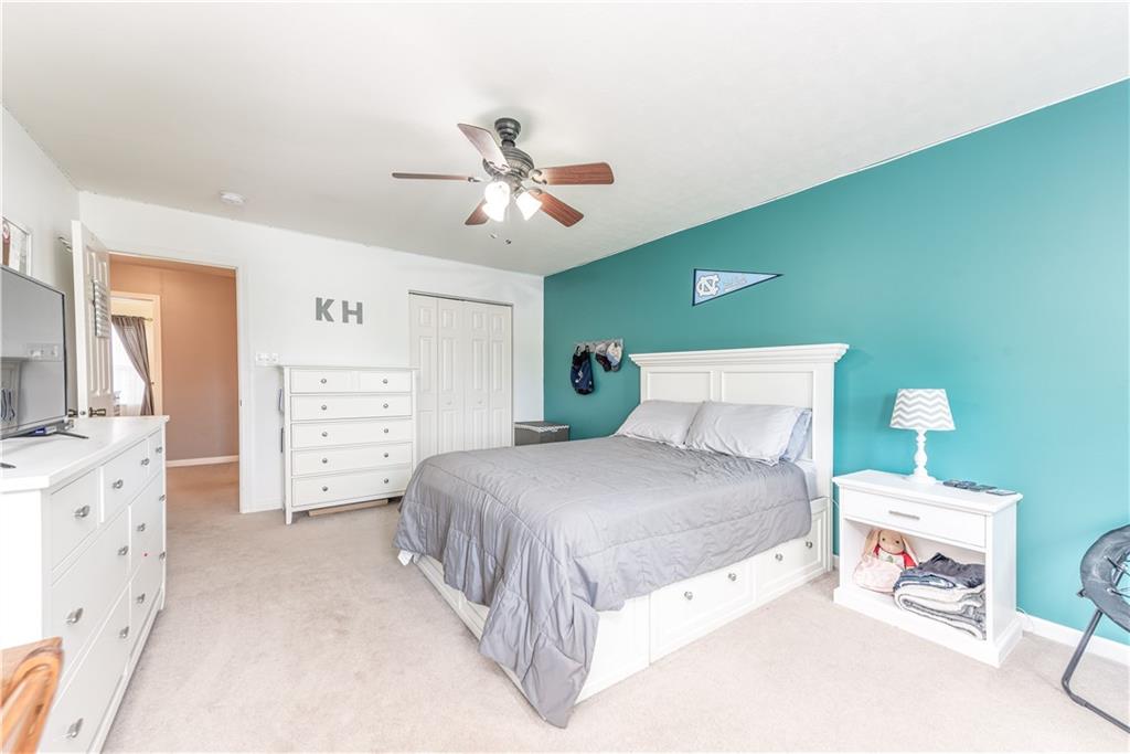 409 Commodore Drive McDonald, PA 15057 - Photo 22 of 49 a spacious bedroom with a bed and a chandelier