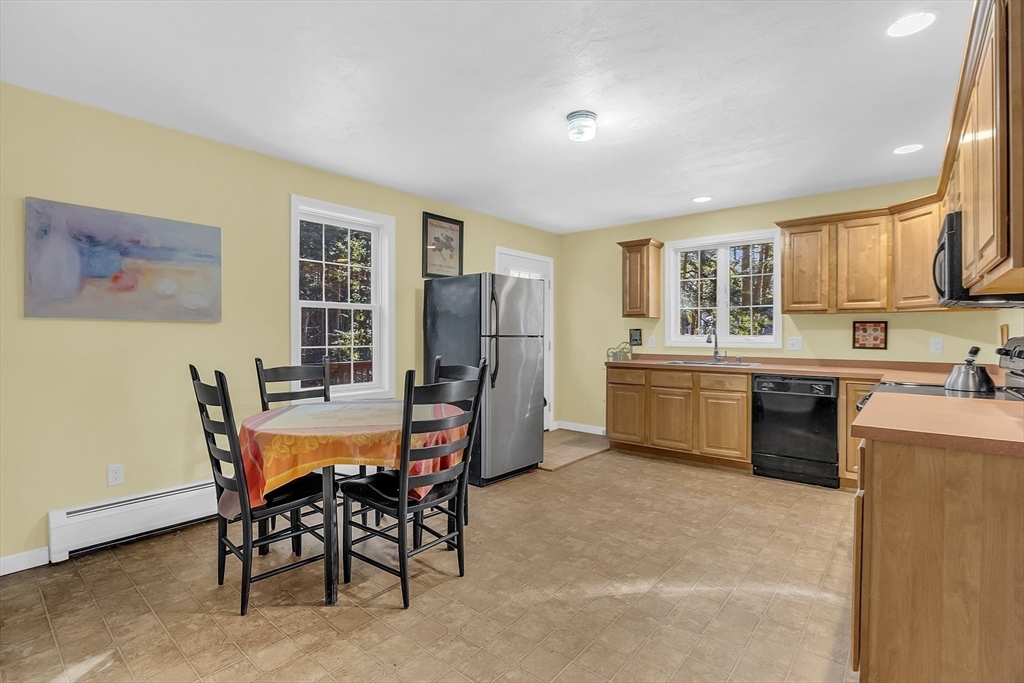 170 E Road, Unit 1 Orange, MA 01364 - Photo 11 of 22 a kitchen with stainless steel appliances a table and chairs in it