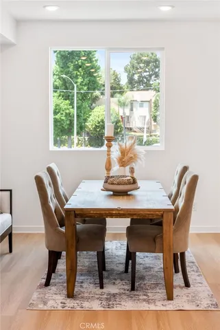 a dining room with furniture window and wooden floor