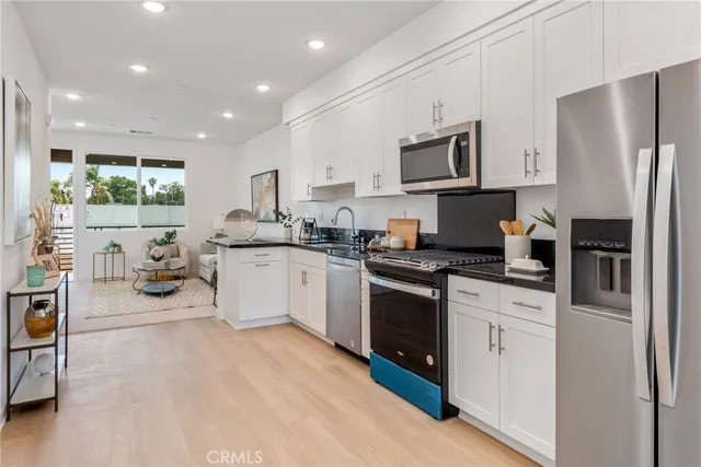 a kitchen with stainless steel appliances granite countertop a refrigerator stove a sink and a microwave