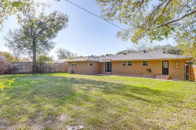 a large house with a big yard and large trees