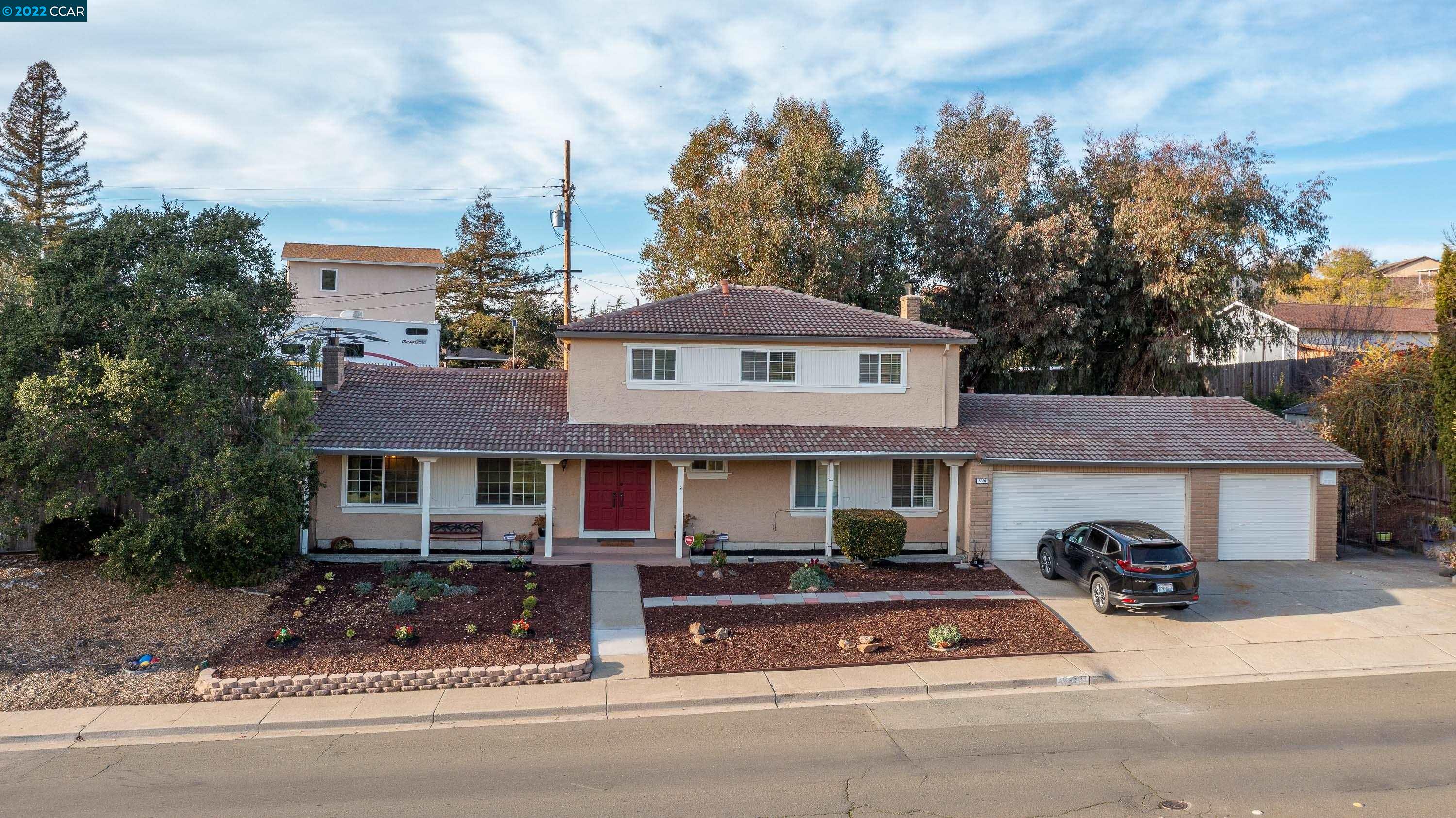 5391 Amend Road El Sobrante, CA 94803 - Photo 1 of 1 a view of a white house with large windows and a table and chairs under an umbrella