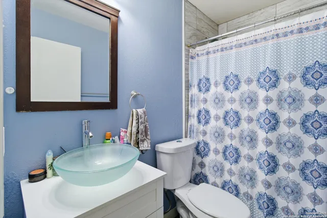 a bathroom with a toilet sink and a mirror