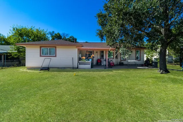 a view of a house with backyard and a tree