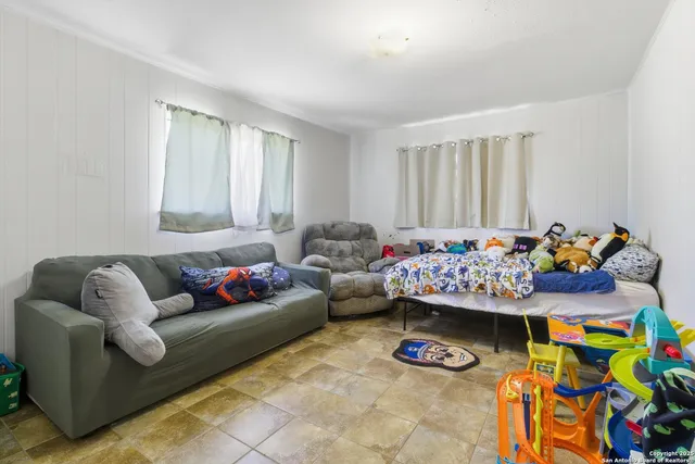 a living room with lots of baby toys and a window