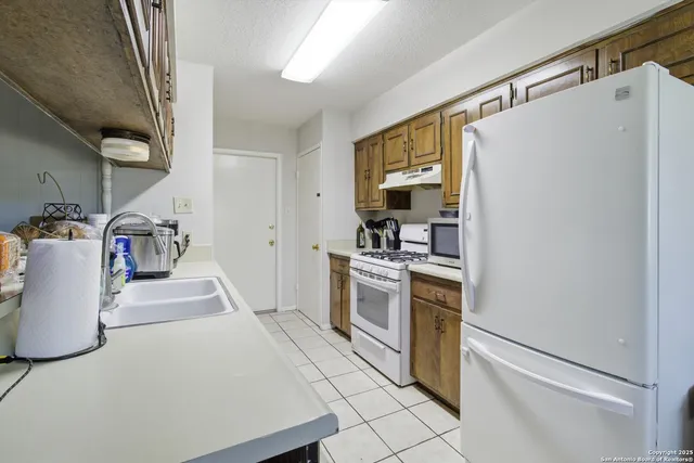 a kitchen with stainless steel appliances a refrigerator sink and stove