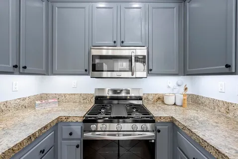 a stove top oven sitting inside of a kitchen