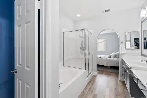 a en suite spacious bathroom with a tub shower and bedroom