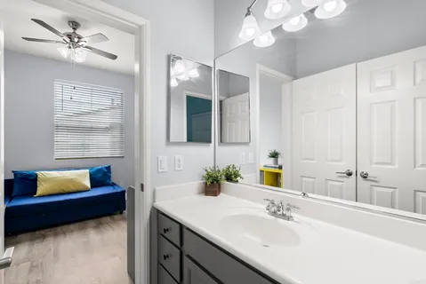 a bathroom with a sink a large mirror and vanity