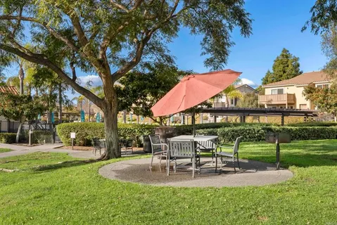 a view of a house with backyard and sitting area