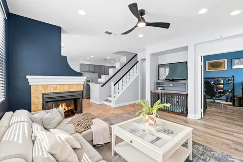 a living room with furniture a fireplace and a flat screen tv