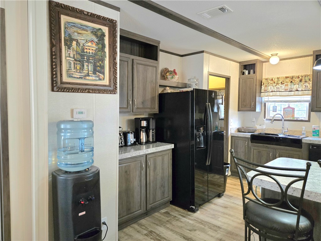 401 Raiders Road Somerville, TX 77879 - Photo 12 of 30 a kitchen with stainless steel appliances a refrigerator a stove a sink dishwasher and a dining table with wooden cabinet