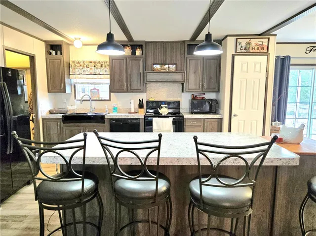 a kitchen with stainless steel appliances kitchen island granite countertop a table chairs in it and wooden floors