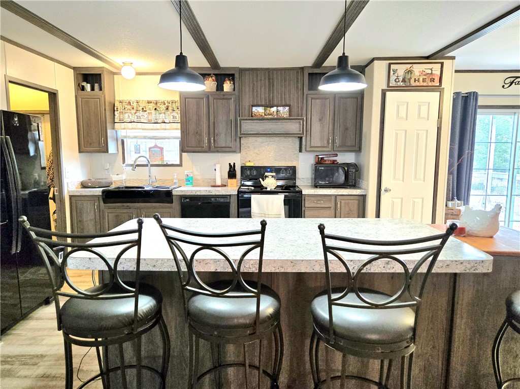 401 Raiders Road Somerville, TX 77879 - Photo 13 of 30 a kitchen with stainless steel appliances kitchen island granite countertop a table chairs in it and wooden floors