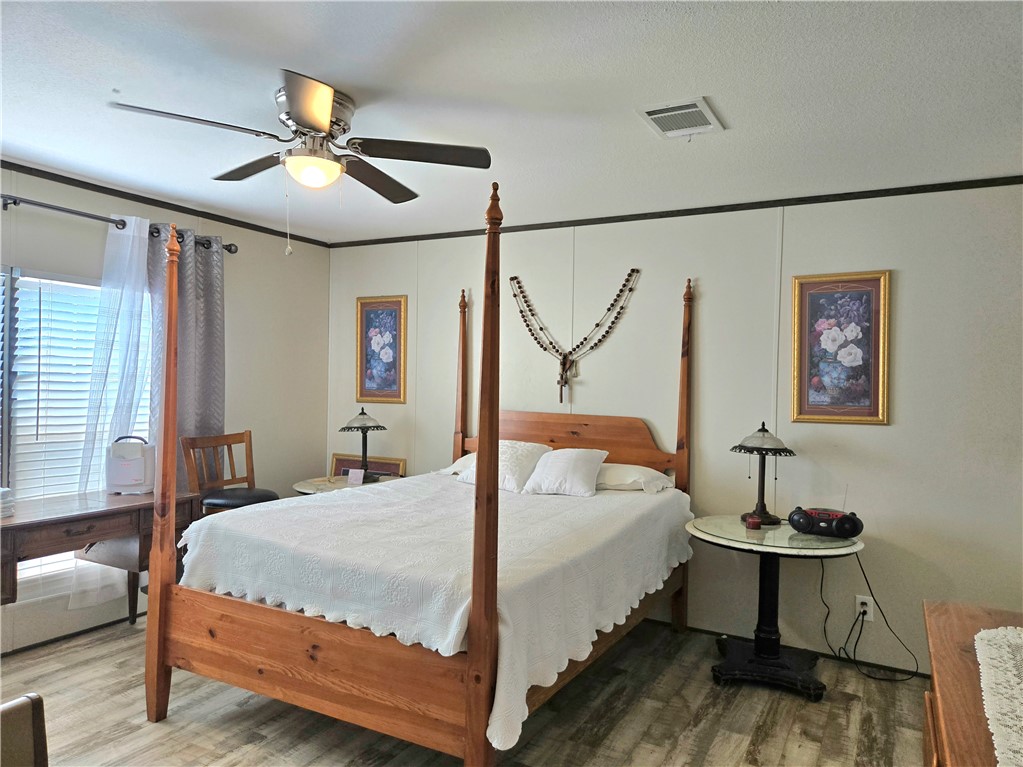 401 Raiders Road Somerville, TX 77879 - Photo 16 of 30 a bedroom with a bed and a chandelier