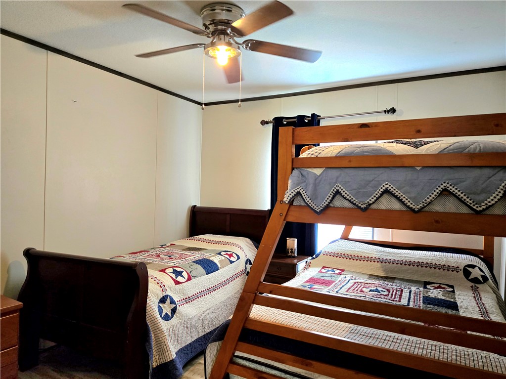 401 Raiders Road Somerville, TX 77879 - Photo 24 of 30 a bedroom with a bed and a chandelier