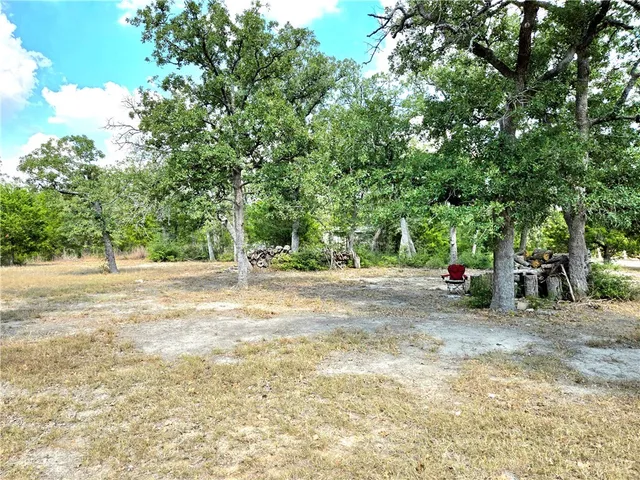 a view of a field with trees in the background