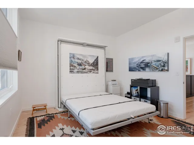 a bedroom with a bed and a wall painting