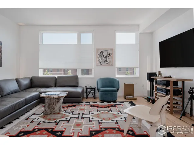 a living room with furniture a flat screen tv and kitchen view