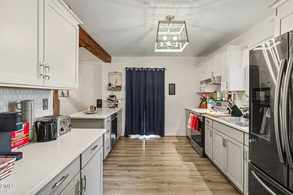 a kitchen with a sink cabinets and wooden floor