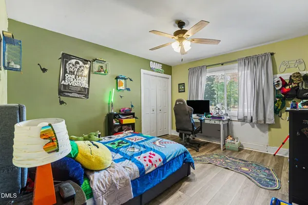 a bedroom with a bed and wooden floor