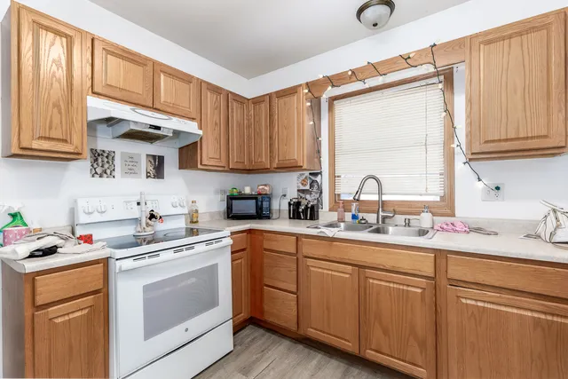 a kitchen with cabinets appliances a sink and a window