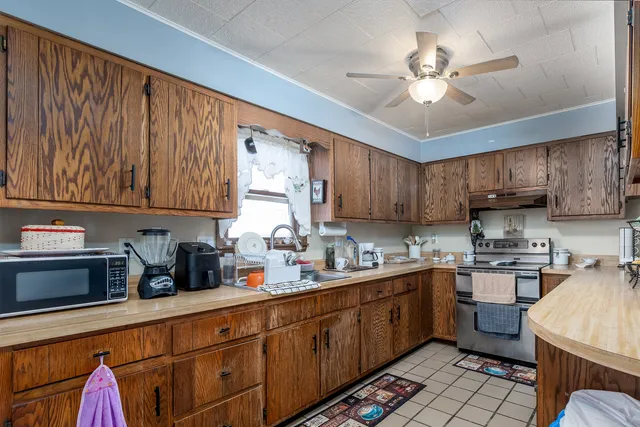 a kitchen with kitchen island granite countertop a sink stainless steel appliances and cabinets