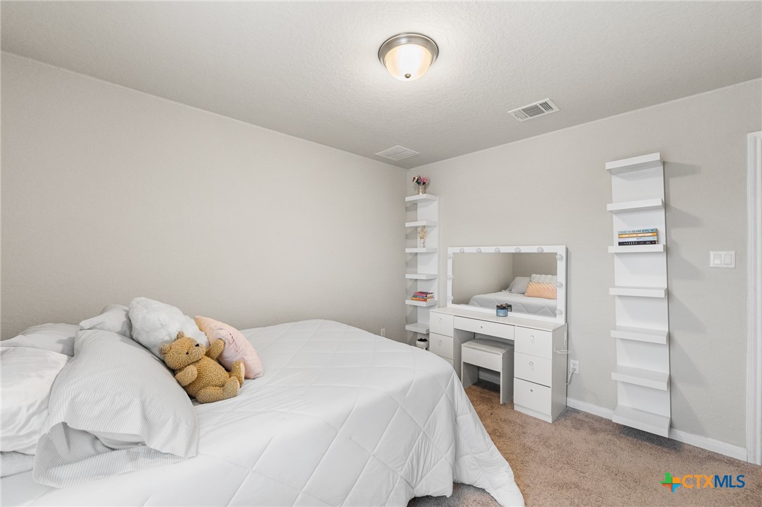 232 Colebrook Way Cibolo, TX 78108 - Photo 31 of 42 a bedroom with a bed and a fireplace
