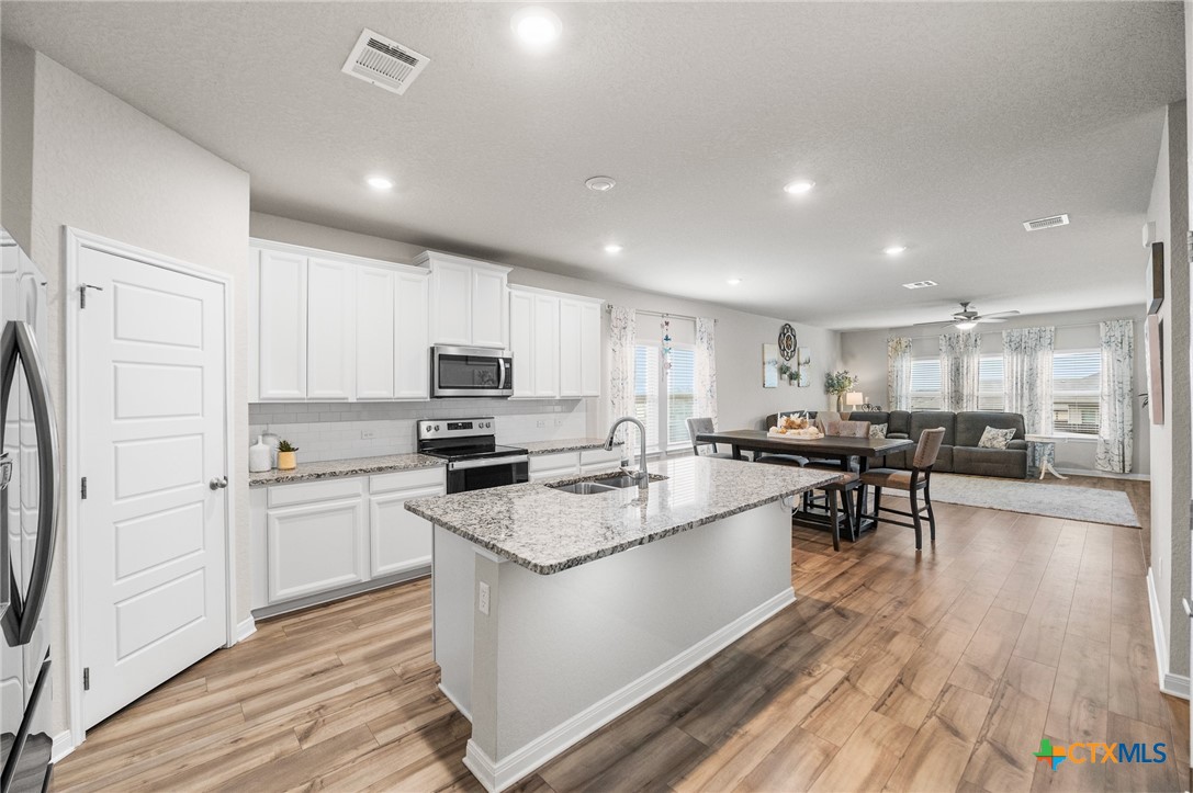 232 Colebrook Way Cibolo, TX 78108 - Photo 6 of 42 a kitchen with white cabinets and stainless steel appliances