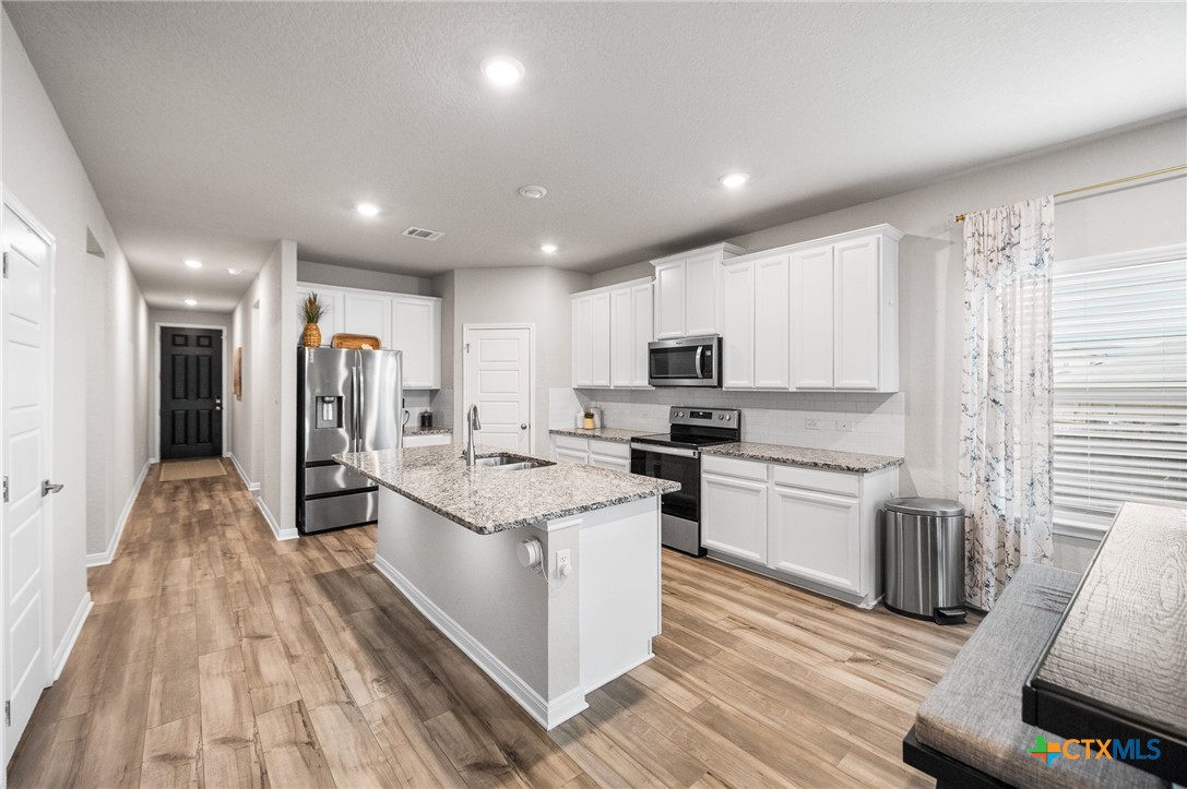 232 Colebrook Way Cibolo, TX 78108 - Photo 7 of 42 a kitchen with stainless steel appliances granite countertop a lot of counter space and wooden floors